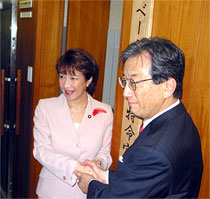 看板かけをする高市大臣（左）と黒川内閣府特別顧問