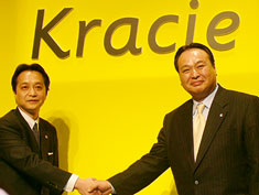 握手する小森社長（左）と中嶋章義会長