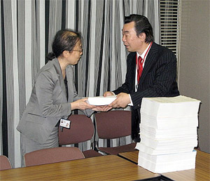 hln201006030301 根本氏(右)が山本氏に署名を手渡す