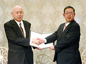 調印後、握手するAJD杉山社長(左)と全日食平野社長