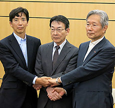 会見後に握手する3者の代表