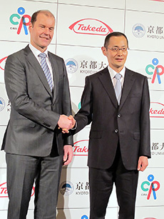 握手するウェバー社長(左)と山中氏