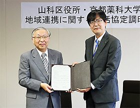 協定書を掲げる京都薬大学長の乾氏(左)、山科区長の堀池氏