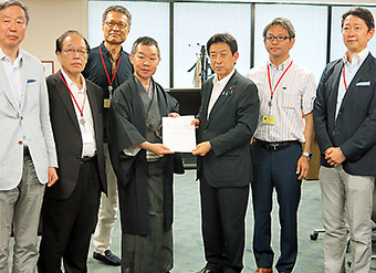 報告書を手渡す本荘座長（中央左）