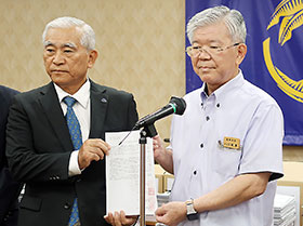 亀谷沖縄県薬会長(左)が大城琉球大学長に要望書と署名を手渡した