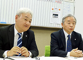 会見する吉田社長(左)と西井会長