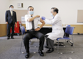 国内で初めて新型コロナウイルスワクチンを接種する新木病院長(中央)