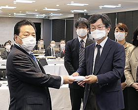 佐藤英道厚労副大臣（左）に答申書を手渡す小塩隆士中医協会長