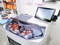 機器上部のカセットから散剤を自動で払い出して分包する