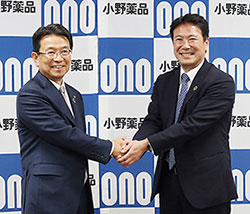 社長交代に向けて握手する滝野氏（右）と相良氏