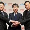 握手するイオンの吉田社長（左）、ツルハHDの鶴羽社長（中央）、ウエルシアHDの松本社長