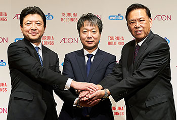 握手するイオンの吉田社長（左）、ツルハHDの鶴羽社長（中央）、ウエルシアHDの松本社長