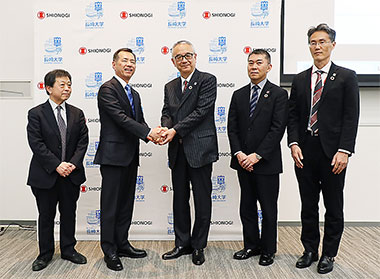 協定書に署名し握手を交わす手代木社長(中央)と、長崎大の永安武学長(左から2人目)