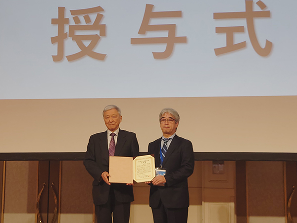 表彰状を授与される麻野井院長(左)