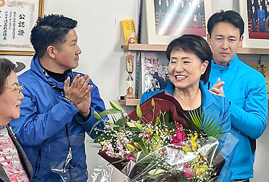 写真上から、当選が決まり、花束を受け取る渡嘉敷氏（右から2人目）と藤田氏（左）