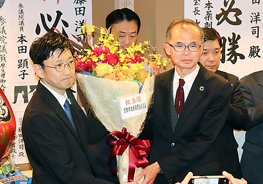 写真上から、当選が決まり、花束を受け取る渡嘉敷氏（右から2人目）と藤田氏（左）