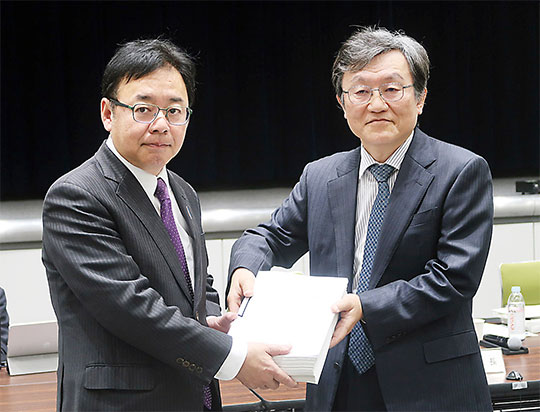 小塩隆士中医協会長（右）から上野賢一郎厚生労働相に答申書が手渡された