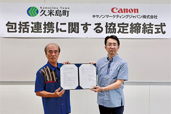 久米島町の桃原秀雄町長(左)とキヤノンMJ執行役員の常信卓也氏